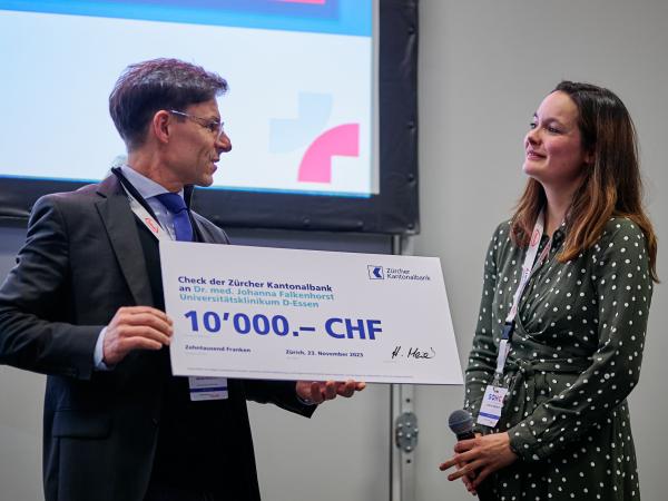 Dr Michael Montemurro hands over the check for the 2023 GIST Prize to Dr Johanna Falkenhorst